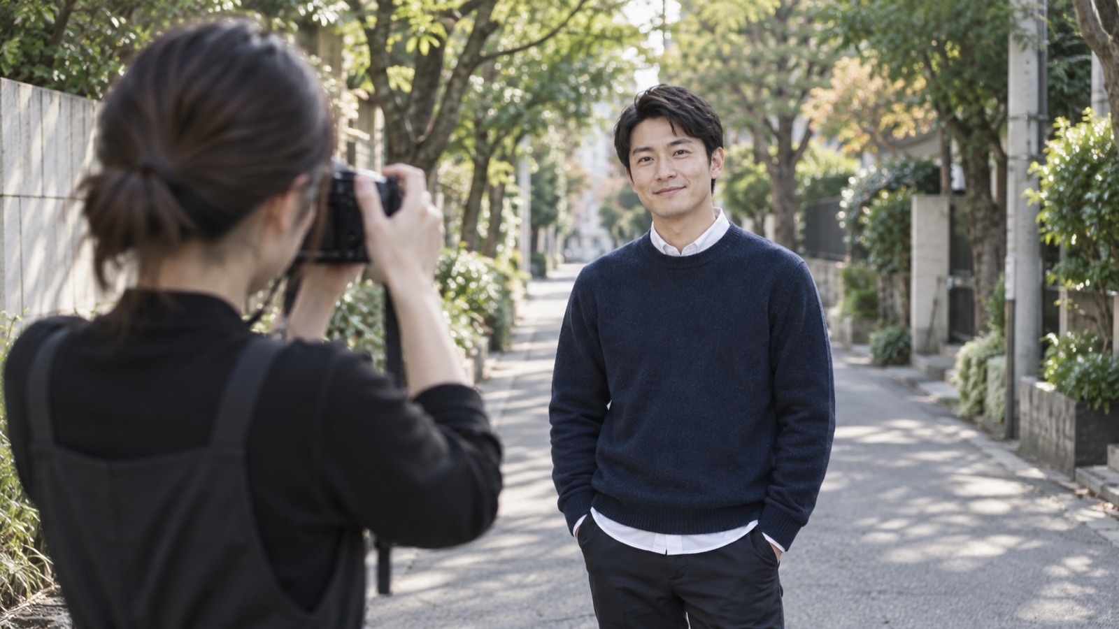 並木道でスタッフに撮影される、やわらかく笑う男性