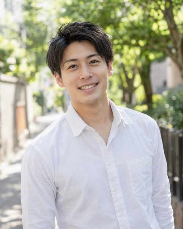 白いシャツで正面から笑う男性