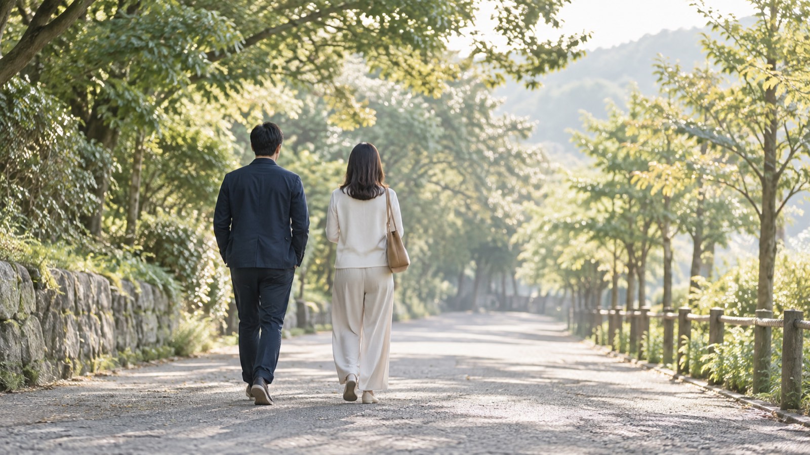 並木道を並んで歩く男女の後ろ姿